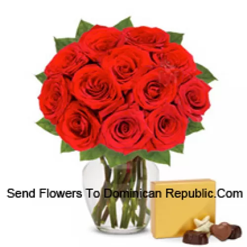 12 roses rouges avec des fougères dans un vase en verre accompagnées d'une boîte de chocolats importée