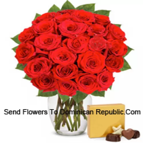 30 roses rouges avec quelques fougères dans un vase en verre accompagnées d'une boîte de chocolats importés