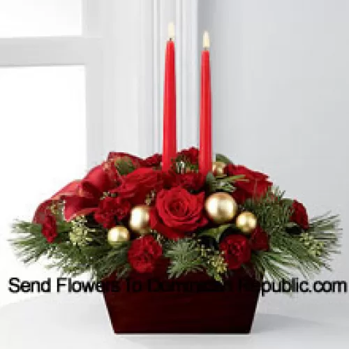 An exquisite display of holiday beauty to add warmth and cheer to their special celebrations. Rich red roses and burgundy mini carnations are set to impress surrounded by lush holiday greens, seeded eucalyptus, gold glass balls and a gold-edged red ribbon arranged elegantly around two red taper candles. Presented in a chocolate brown bamboo container, this centerpiece will usher in joy and goodwill with each treasured bloom (Please Note That We Reserve The Right To Substitute Any Product With A Suitable Product Of Equal Value In Case Of Non-Availability Of A Certain Product)